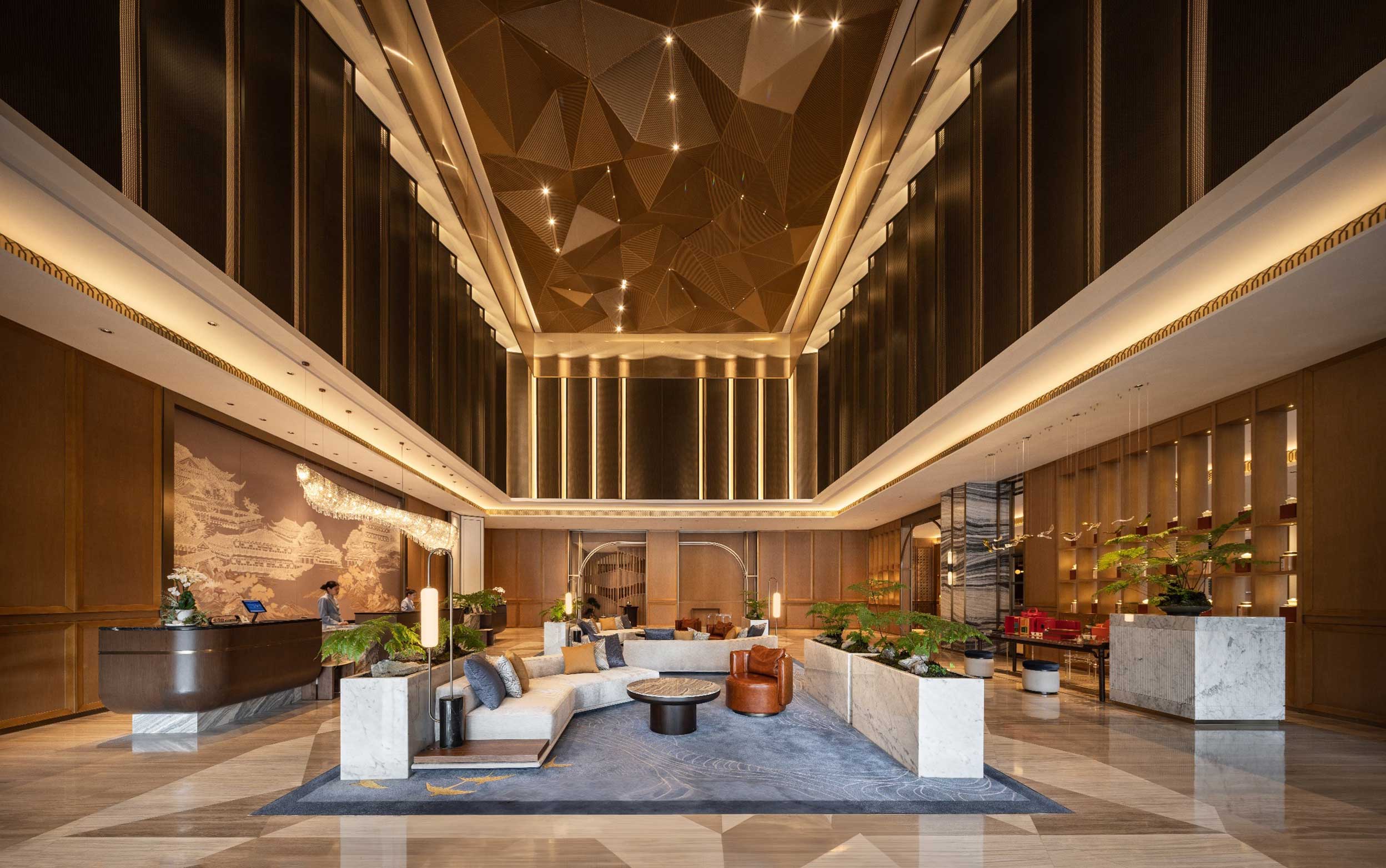 Luxurious hotel lobby with high ceilings and geometric lighting. Features elegant seating, lush plants, and a warm, inviting ambiance.
