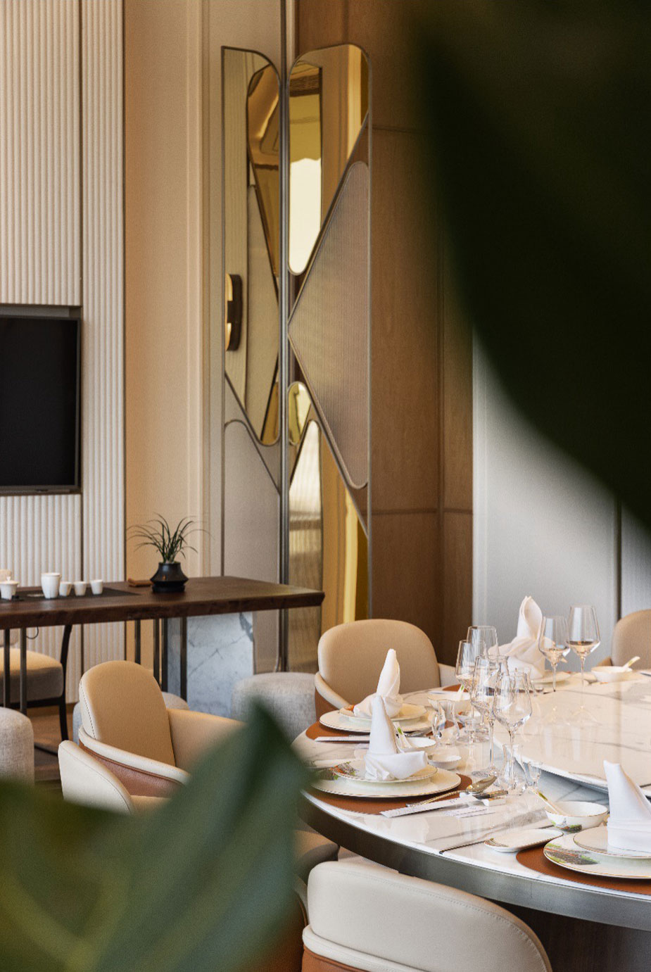 Elegant dining room with a round table set for six, featuring white napkins and glassware. Beige chairs, decorative mirrors, and a serene ambiance.