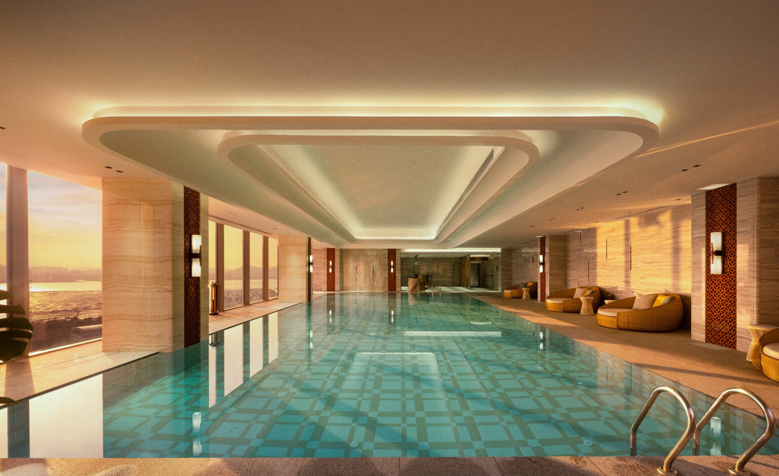 Luxurious indoor pool with a geometric patterned floor, surrounded by plush seating. Large windows reveal a serene sunset over water, creating a tranquil ambiance.