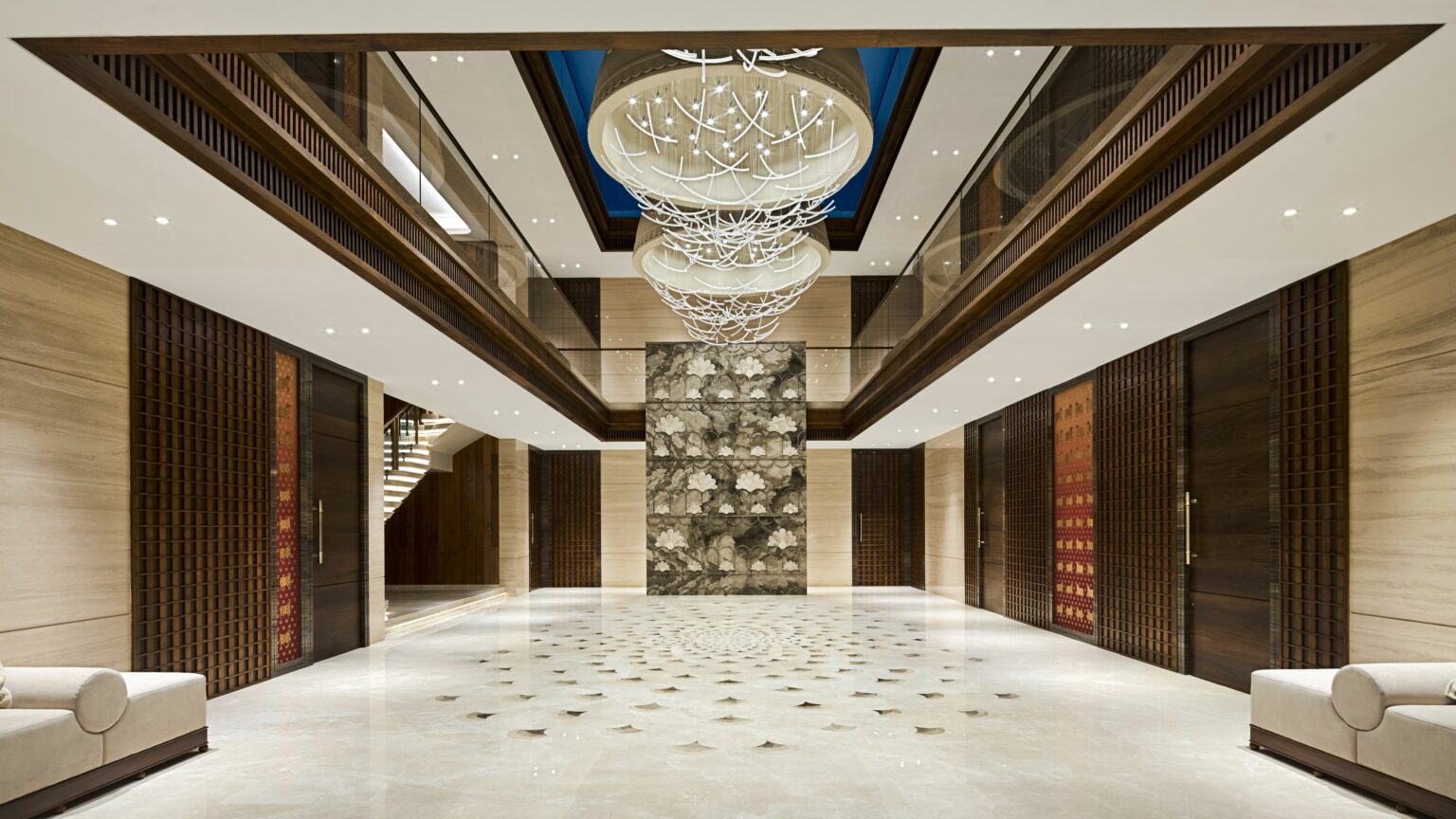 Luxurious lobby with marble floors, intricate chandeliers, and modern decor. Warm lighting, elegant seating, and a serene, sophisticated ambiance.