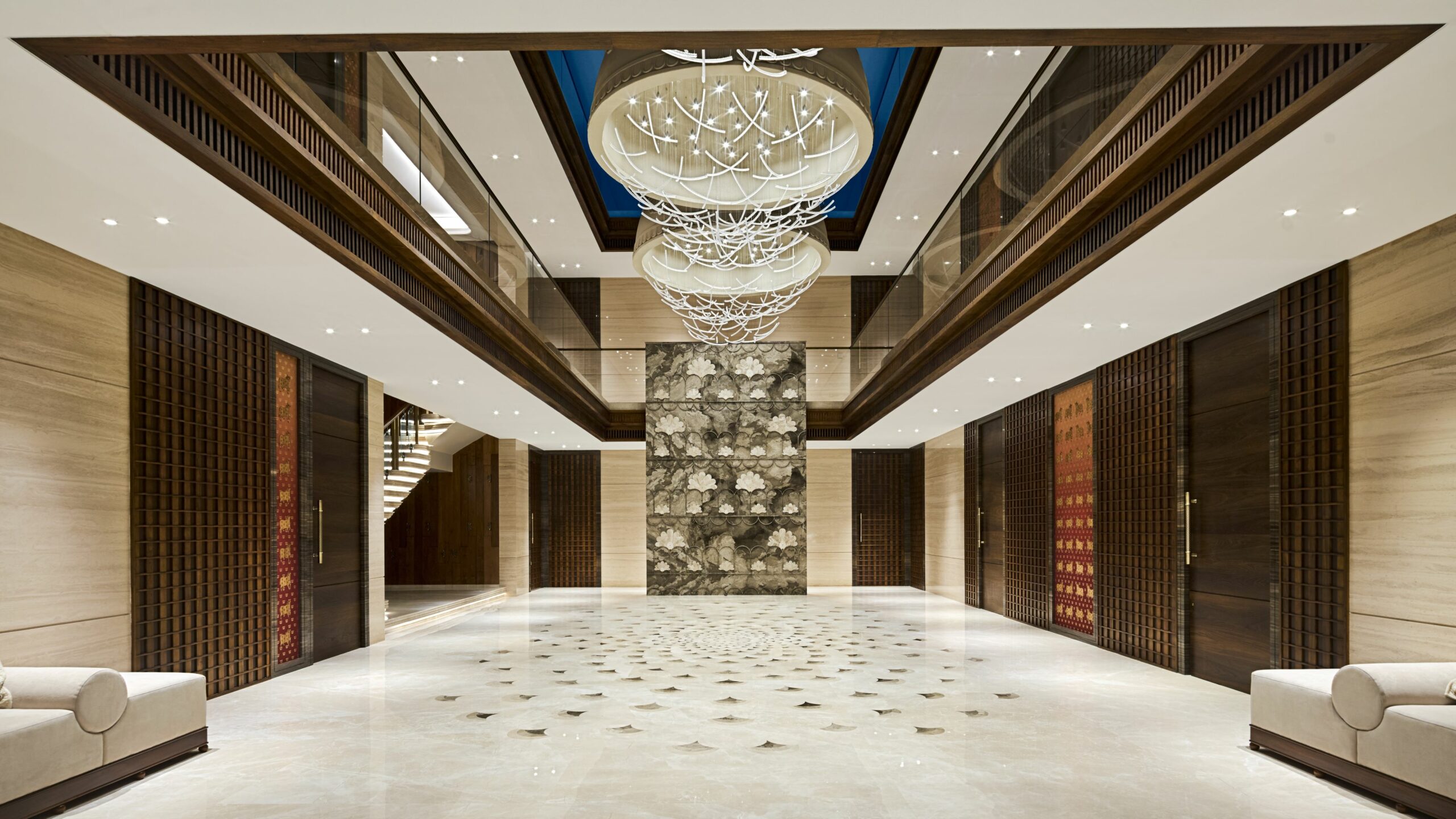 Luxurious lobby with marble floors, intricate chandeliers, and modern decor. Warm lighting, elegant seating, and a serene, sophisticated ambiance.